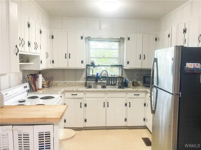 kitchen featuring a sink, visible vents, white cabinetry, appliances with stainless steel finishes, and light floors