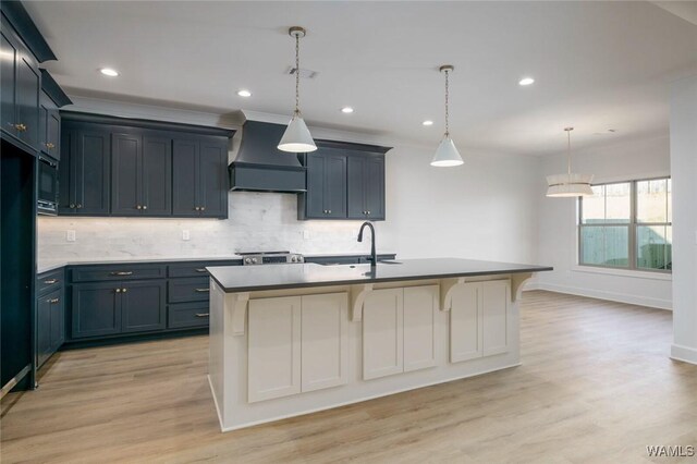 13713 Blackoak Dr, Northport, AL 35475 - kitchen featuring a kitchen island with sink, light wood-style flooring, a sink, custom exhaust hood, and tasteful backsplash