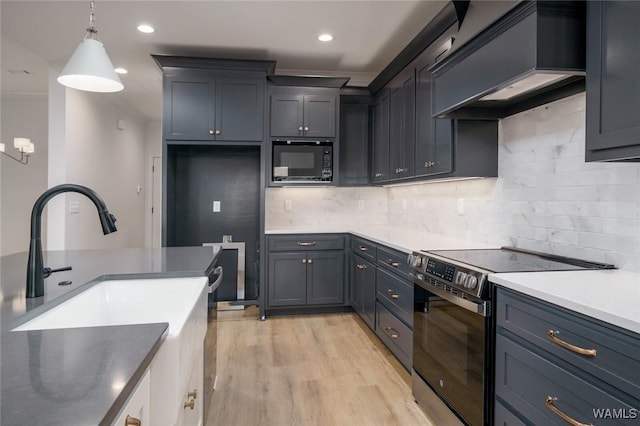 13713 Blackoak Dr, Northport, AL 35475 - kitchen with pendant lighting, stainless steel electric range oven, tasteful backsplash, light wood-style flooring, and black microwave