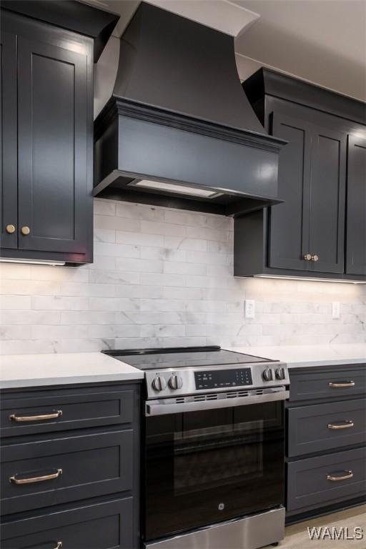 13713 Blackoak Dr, Northport, AL 35475 - kitchen with custom range hood, light countertops, decorative backsplash, and stainless steel electric stove
