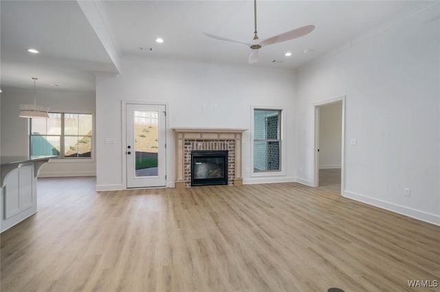 13713 Blackoak Dr, Northport, AL 35475 - unfurnished living room with baseboards, a brick fireplace, a ceiling fan, and light wood-style floors