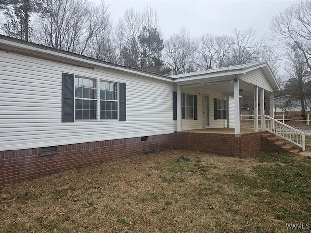 view of side of home featuring a yard and a patio area