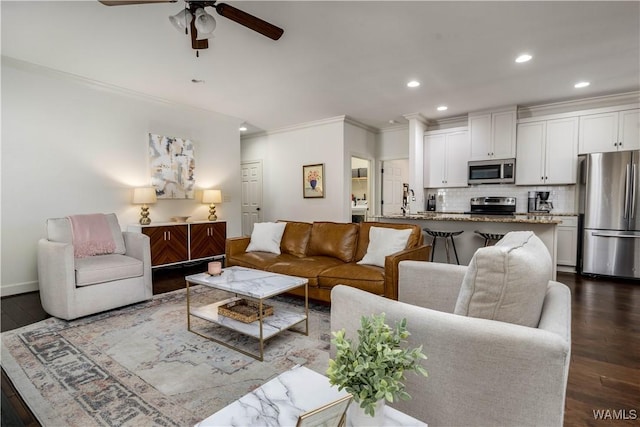 living area with dark wood-type flooring, recessed lighting, a ceiling fan, and crown molding