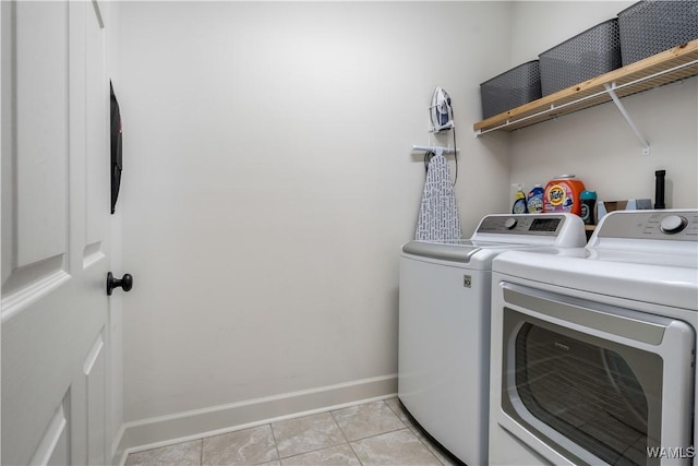 clothes washing area featuring baseboards, light tile patterned floors, laundry area, and independent washer and dryer