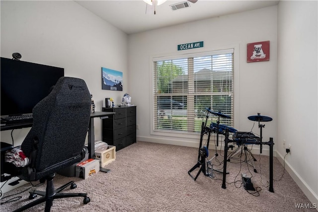 carpeted office space with baseboards, visible vents, and a ceiling fan