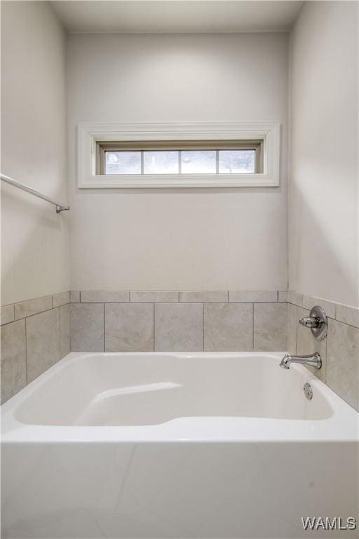 bathroom with a garden tub and plenty of natural light