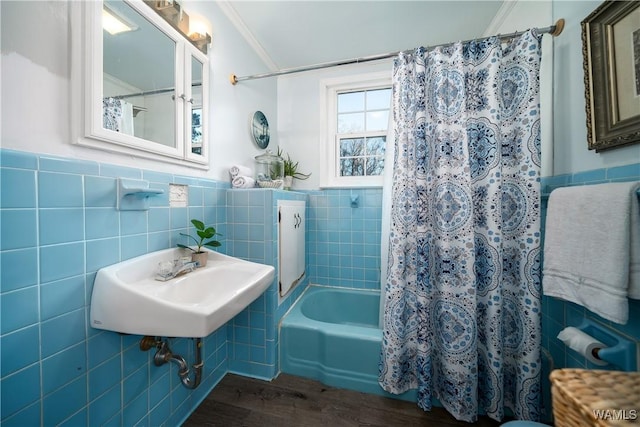 bathroom featuring sink, hardwood / wood-style floors, tile walls, and shower / bath combo