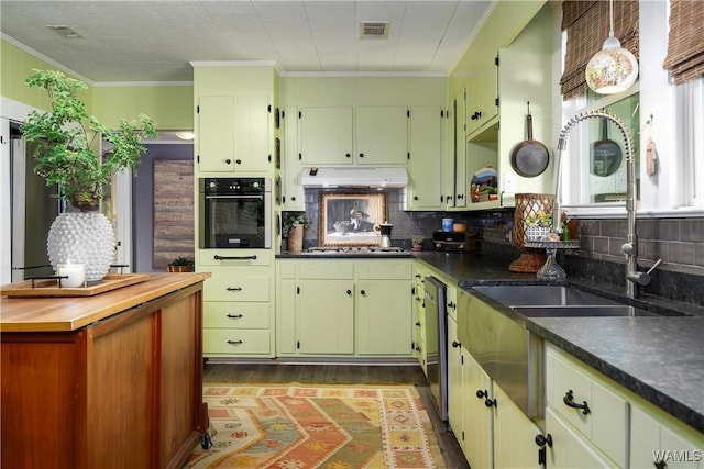 kitchen featuring crown molding, oven, and backsplash