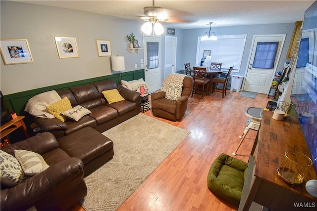 living room featuring hardwood / wood-style flooring and ceiling fan with notable chandelier