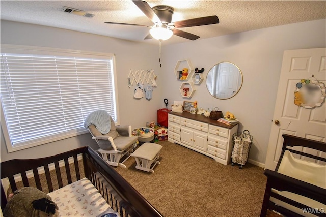 carpeted bedroom featuring ceiling fan and a textured ceiling