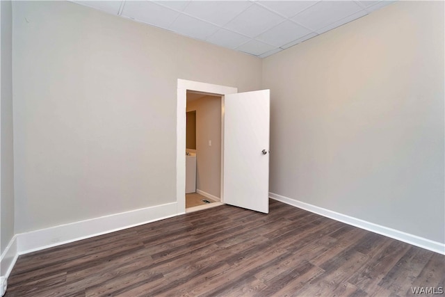 unfurnished room featuring a paneled ceiling and dark wood-type flooring