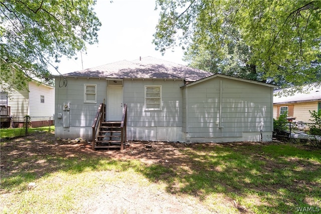 rear view of property featuring a lawn