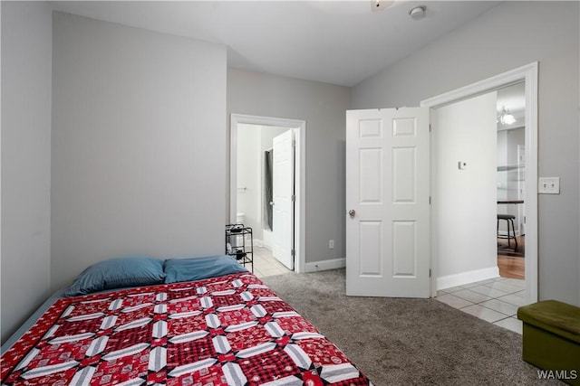 bedroom with light tile patterned floors, baseboards, and light colored carpet