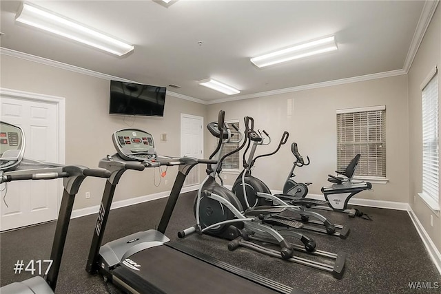 exercise room with baseboards and ornamental molding