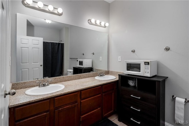 bathroom with tile patterned flooring, double vanity, a shower with shower curtain, and a sink