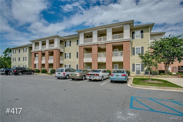 view of property featuring central AC and uncovered parking