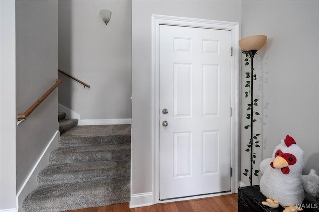 stairway featuring baseboards and wood finished floors