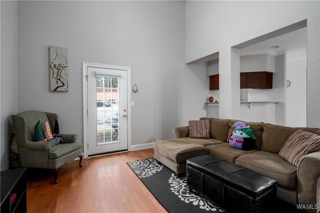 living room with a high ceiling, baseboards, and hardwood / wood-style flooring