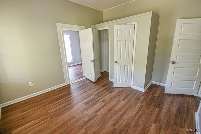 unfurnished bedroom featuring dark wood-type flooring and a closet