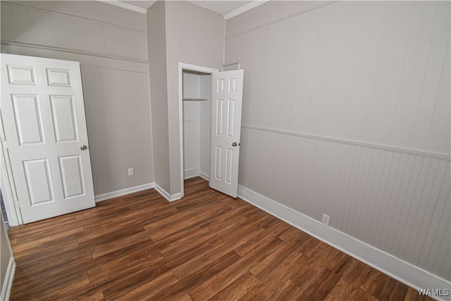 unfurnished bedroom with wood walls, dark hardwood / wood-style flooring, and ornamental molding