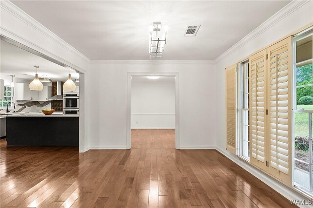 600 Innsbruck Ct, Northport, AL 35473 - unfurnished dining area with wood-type flooring and crown molding