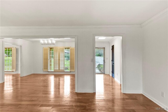 600 Innsbruck Ct, Northport, AL 35473 - empty room with crown molding, light wood-style floors, and a chandelier
