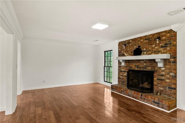 600 Innsbruck Ct, Northport, AL 35473 - unfurnished living room with hardwood / wood-style floors, crown molding, and a brick fireplace