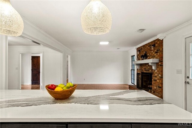 600 Innsbruck Ct, Northport, AL 35473 - kitchen featuring a brick fireplace, ornamental molding, open floor plan, wood finished floors, and light countertops