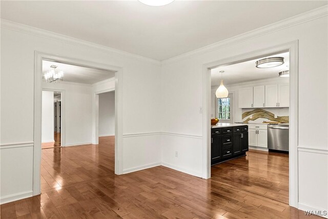 600 Innsbruck Ct, Northport, AL 35473 - unfurnished dining area featuring wood finished floors, ornamental molding, and a chandelier