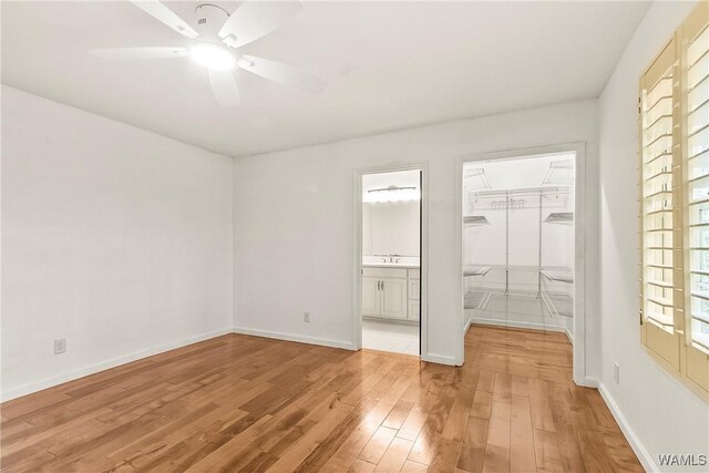 600 Innsbruck Ct, Northport, AL 35473 - unfurnished bedroom featuring wood finished floors, ensuite bathroom, a spacious closet, ceiling fan, and a closet
