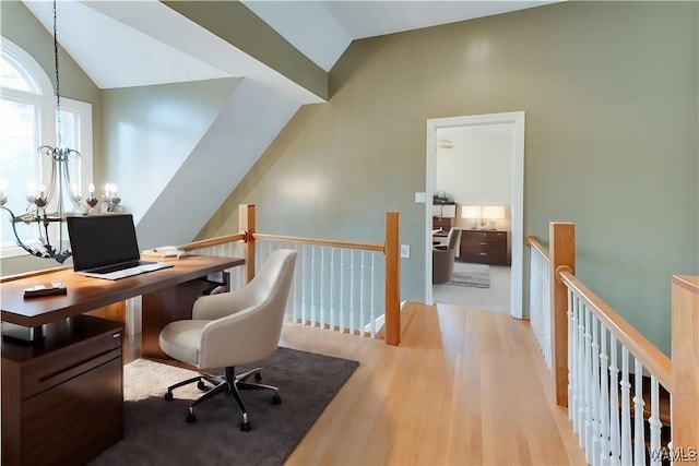 office space featuring light hardwood / wood-style floors, lofted ceiling, and an inviting chandelier