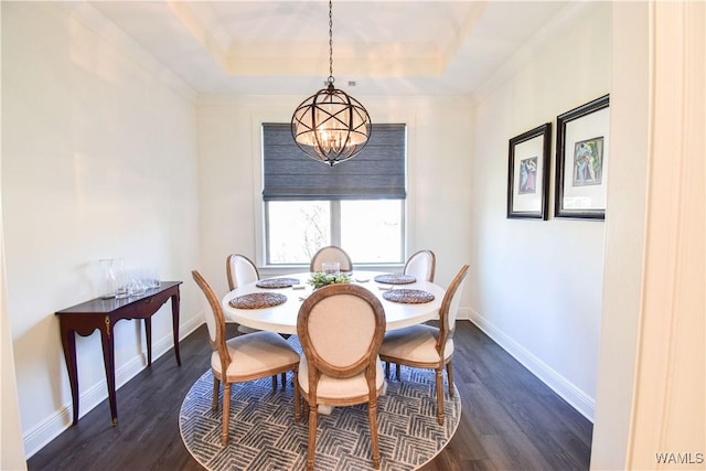 dining space featuring baseboards, a chandelier, a raised ceiling, and dark wood-style flooring