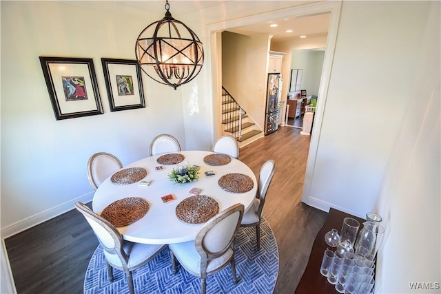 dining area featuring stairs, dark wood-type flooring, a chandelier, and baseboards