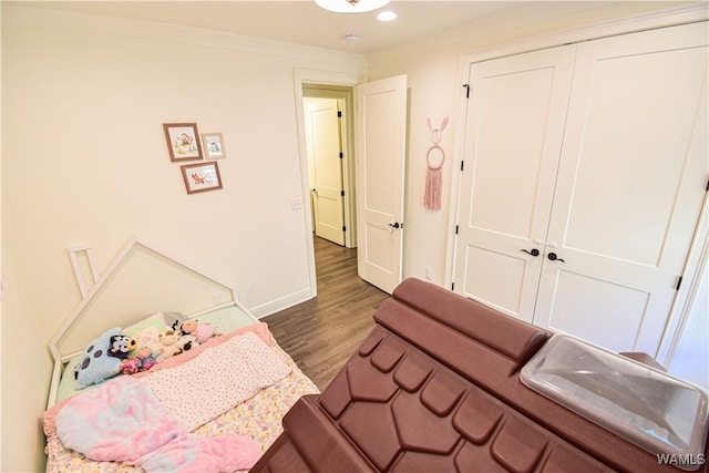 bedroom featuring a closet, wood finished floors, and baseboards