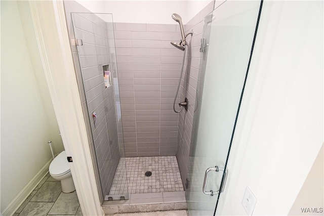 full bathroom with tile patterned flooring, a shower stall, toilet, and baseboards