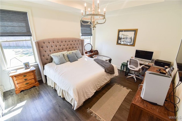 bedroom with dark wood-type flooring, multiple windows, a notable chandelier, and baseboards