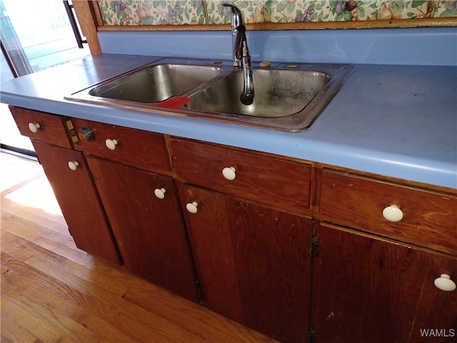 details featuring light hardwood / wood-style flooring and sink