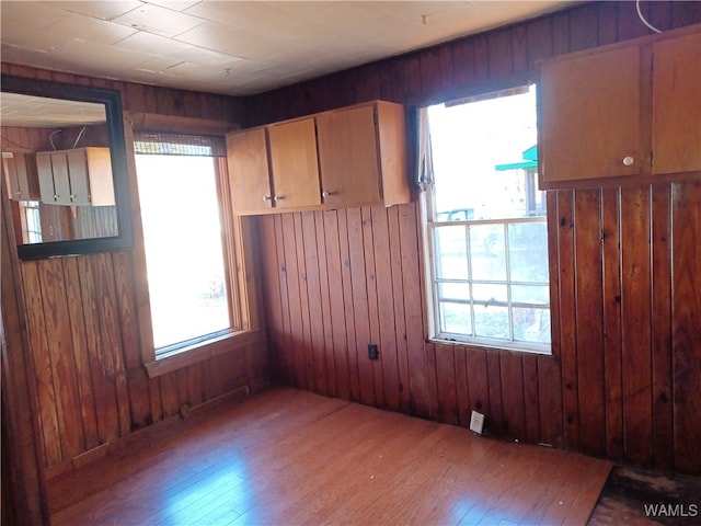 empty room featuring hardwood / wood-style flooring and wooden walls