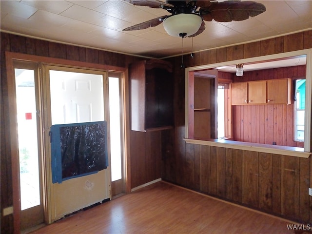 entrance foyer with wood walls, ceiling fan, and hardwood / wood-style flooring