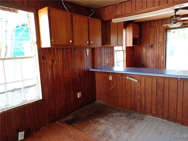 kitchen featuring a wealth of natural light, dark hardwood / wood-style flooring, and wood walls