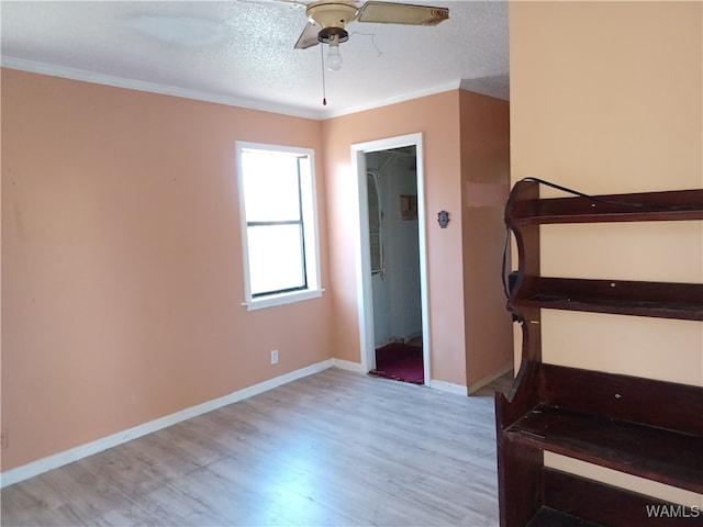 stairs featuring a textured ceiling, hardwood / wood-style flooring, ceiling fan, and crown molding