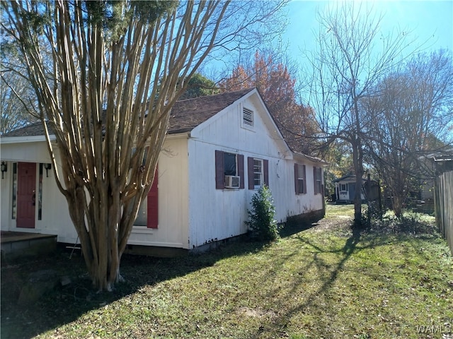 view of side of property with cooling unit and a lawn