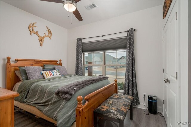 bedroom with hardwood / wood-style flooring, ceiling fan, and a closet