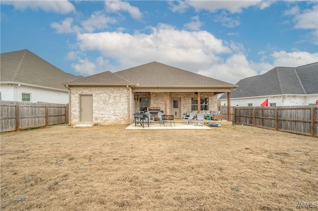 back of house with a patio and a yard