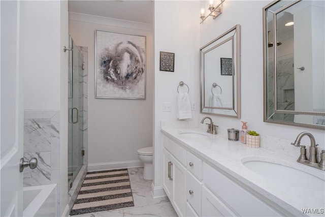 bathroom featuring vanity, ornamental molding, toilet, and a shower with shower door