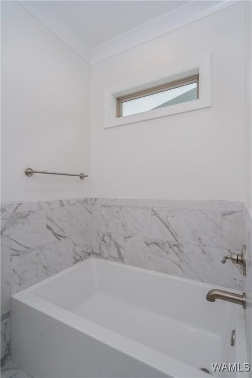 bathroom with a bathtub and crown molding