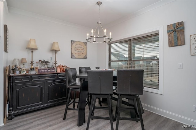 dining room featuring an inviting chandelier, ornamental molding, and hardwood / wood-style floors