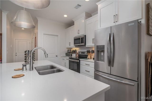 kitchen with sink, crown molding, hanging light fixtures, stainless steel appliances, and white cabinets