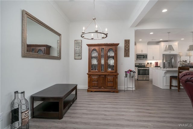 interior space featuring sink, hardwood / wood-style flooring, ornamental molding, and a chandelier