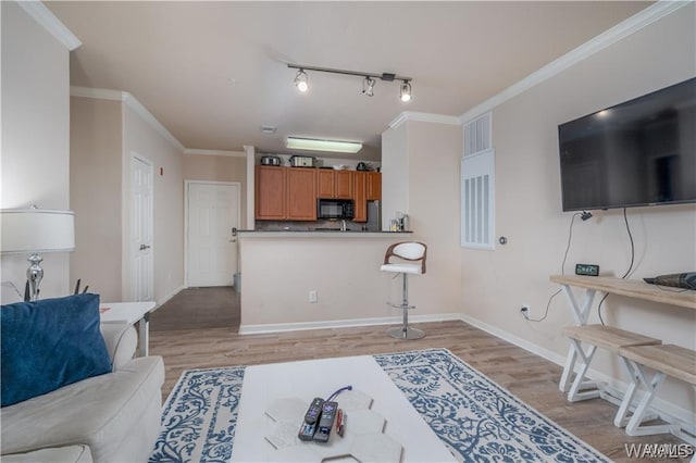 living room with crown molding, track lighting, and light hardwood / wood-style floors